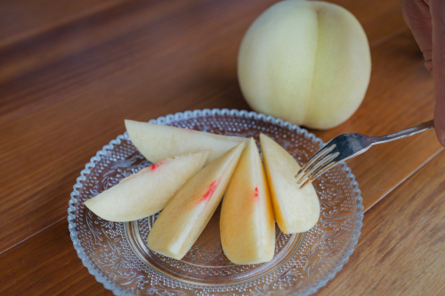 切った桃を載せた皿とフォーク
